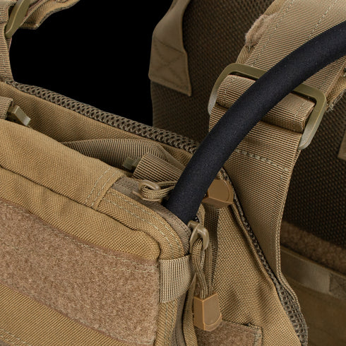 Close-up of the Condor Tidepool Hydration Carrier in tan, featuring a black hydration tube from a zippered pocket and adjustable shoulder straps—perfect for military use or the shooting range.